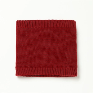 Detailed view of red knitted infinity scarf showing thick moss stitch texture and ribbed edges