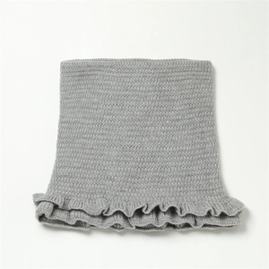 Detail eines grauen Strickschals mit zartem Volantsaum und gerippter Textur für Winter