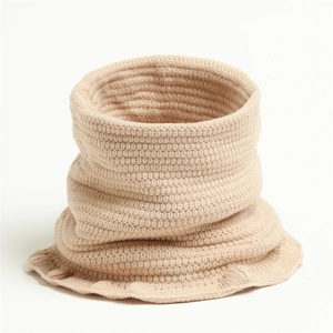 Detail eines beigen Strickschals mit dicker Textur und gewelltem Rand für den Winter