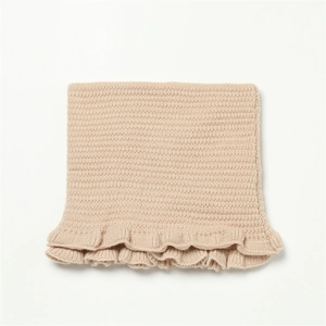 Detail eines hellbraunen Strickschals mit feiner Webstruktur und gewelltem Rüschenrand