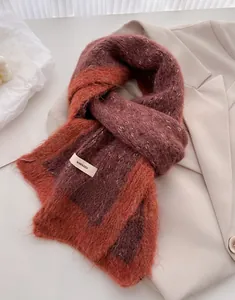 Close-up of color-block knit scarf with brand tag placed on a beige blazer