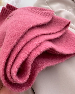 Close-up of thick pink knit scarf with soft mohair texture and neat stitching details