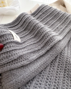 Macro shot of grey wool knit scarf texture with vertical weave and brand label detail