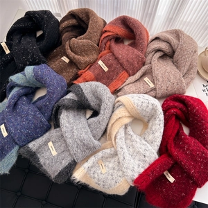 Flat lay of eight colorful chunky knit scarves showing diverse fabric textures and labels