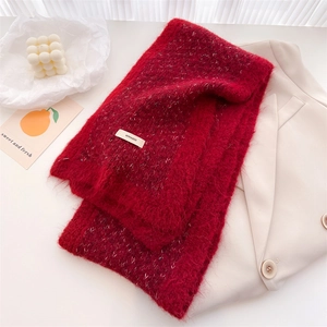 Close-up of fluffy burgundy wool knit scarf with brand label and stylish warm texture