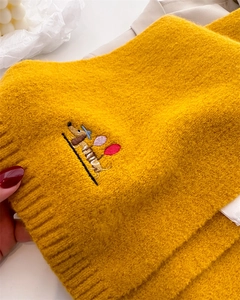 Detail of yellow knit scarf featuring a cute dachshund embroidery with balloon accents