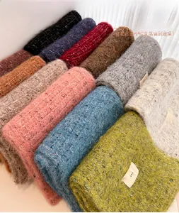 Detail shot of multicolor wool blend knit scarves with plush texture and woven labels