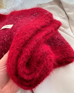 Detail view of red mohair wool scarf showing fuzzy plush texture and woven brand label