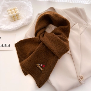Close-up of dark brown knit scarf featuring detailed dog embroidery and soft texture