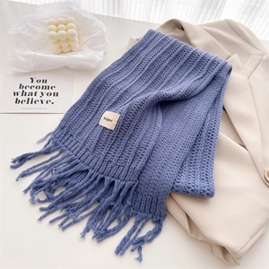 Detailed texture of royal blue wool knit scarf with thick stripes and soft fringe