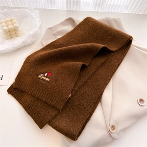 Close-up of knit scarf showing dark coffee texture and colorful dachshund embroidery