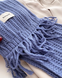 Close-up of foggy blue cable knit wool scarf with tassel detail and soft texture