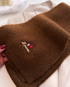 Detail of brown knit scarf featuring a cute dachshund embroidery with colorful balloons