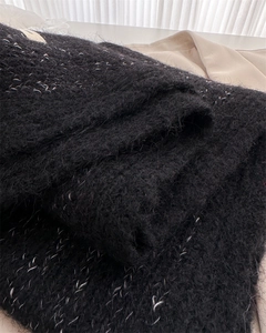 Detailed macro shot of black mohair scarf with shimmering silver metallic thread details