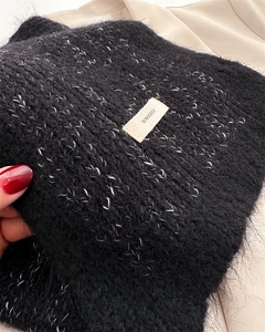 Detail of soft mohair knit scarf with white speckled fibers and branded label patch