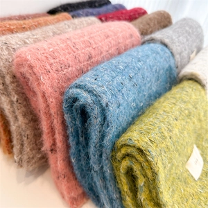 Detailed close-up showing soft wool blend knitted fabric texture with colorful yarn flecks