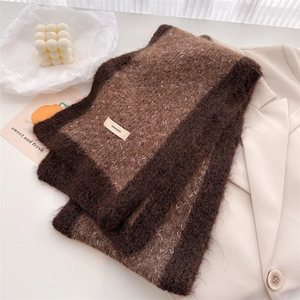 Macro detail of thick knitted winter scarf with brand tag on warm brownish wool fabric