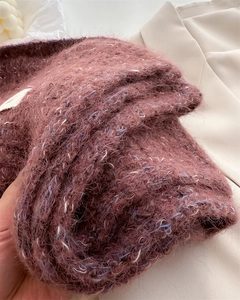 Macro shot of fluffy dusty pink knit wool scarf texture with soft blue and white yarn