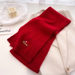 Detail of red knit scarf with cute dachshund embroidery on a white blazer