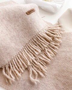 Detail of oat-beige knit scarf texture with fringe and leather Hand Made label