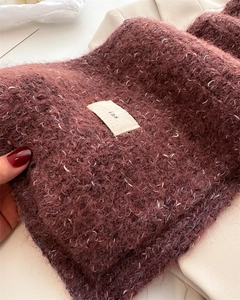 Close-up of red-brown wool blend scarf showing fuzzy texture and ins logo label