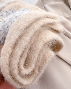 Close-up of fluffy beige wool knit scarf with soft texture and delicate long fibers