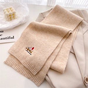 Detail of beige knit scarf featuring dachshund and balloon embroidery with ribbed edges