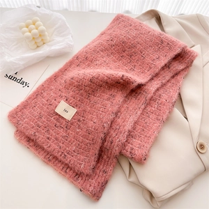 Close-up of pink wool knit scarf with soft mohair texture and minimalist cloth label