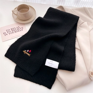 Detailed view of knitted black scarf featuring dachshund and balloon embroidery accents