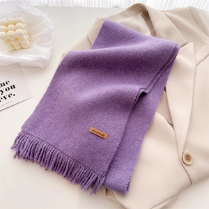 Detail of purple knitted scarf with short fringe and brown leather handmade tag