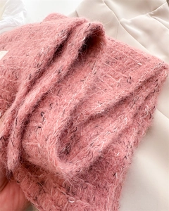Macro shot of fluffy pink wool knit fabric showing soft texture and detailed knit pattern