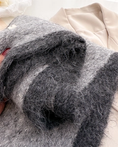 Close-up of thick grey fuzzy knit scarf showing premium wool texture and soft long fibers