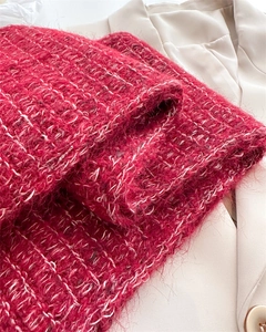 Macro view of red wool blend knit scarf texture with white grid pattern on beige blazer