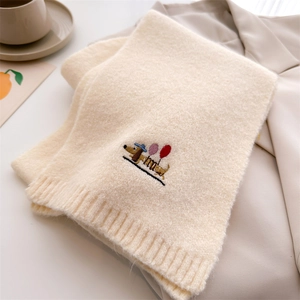 Close-up of beige knitted scarf featuring cute dachshund embroidery with balloons