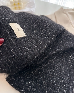 Close-up of soft black and white wool blend knit scarf with fluffy texture and ins label