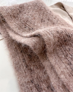 Close-up of soft brown wool knit texture and fuzzy mohair fabric on winter scarf