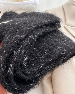 Detail of black wool knit shawl with silver metallic yarn and fuzzy mohair texture
