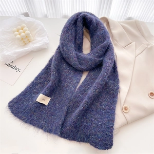 Detail of purple mohair knit scarf texture with a small ins tag on a white table