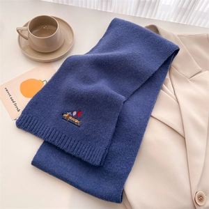 Detail of dark blue knit scarf with embroidered dachshund and colorful balloon design