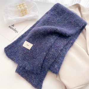 Detail of blue wool-blend knit scarf showing soft long-hair texture and woven label