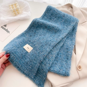 Close-up of blue wool blend scarf with fluffy mohair texture and minimalist ins tag