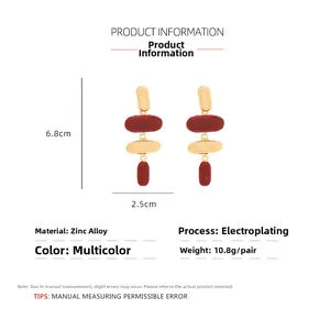 Vue détaillée des boucles d'oreilles rétro géométriques en émail rouge et doré