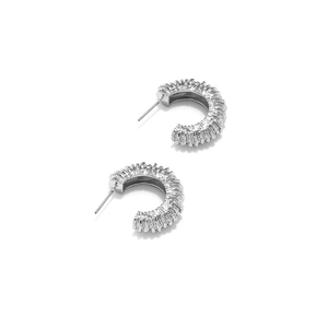 Détail des boucles d'oreilles argentées en forme de C avec texture verticale en relief