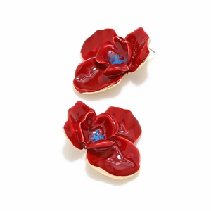 Vue détaillée de boucles d'oreilles fleurs en émail rouge avec accents dorés