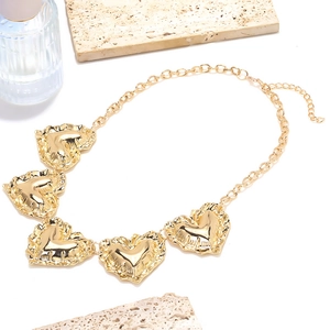 Collana vintage dorata con cinque ciondoli a cuore bombati su una catena a maglie spesse