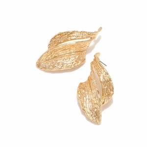 Macro shot of gold geometric earrings featuring detailed leaf-like metal texture