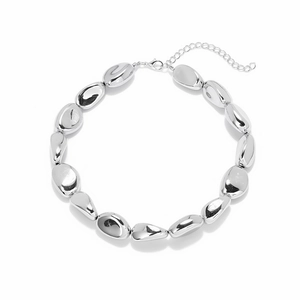 Detail of silver metallic beaded necklace with irregular organic pebble-shaped modules