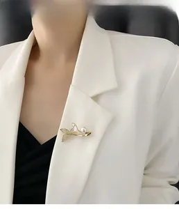 Close-up of a gold honeybee brooch with pearls and zircons on a white blazer lapel