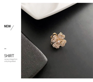 Detailed view of rotatable golden flower brooch featuring shimmering zircon petals