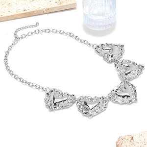 Dettaglio di cinque ciondoli a cuore argento con trama stropicciata su catena a maglie grandi